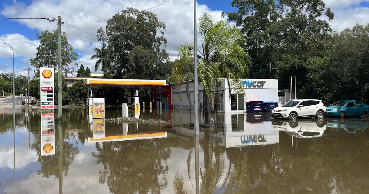 a flooded gas station with cars parked in it