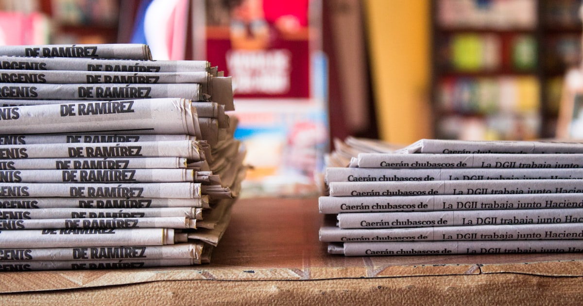 a stack of newspapers sitting on top of a table