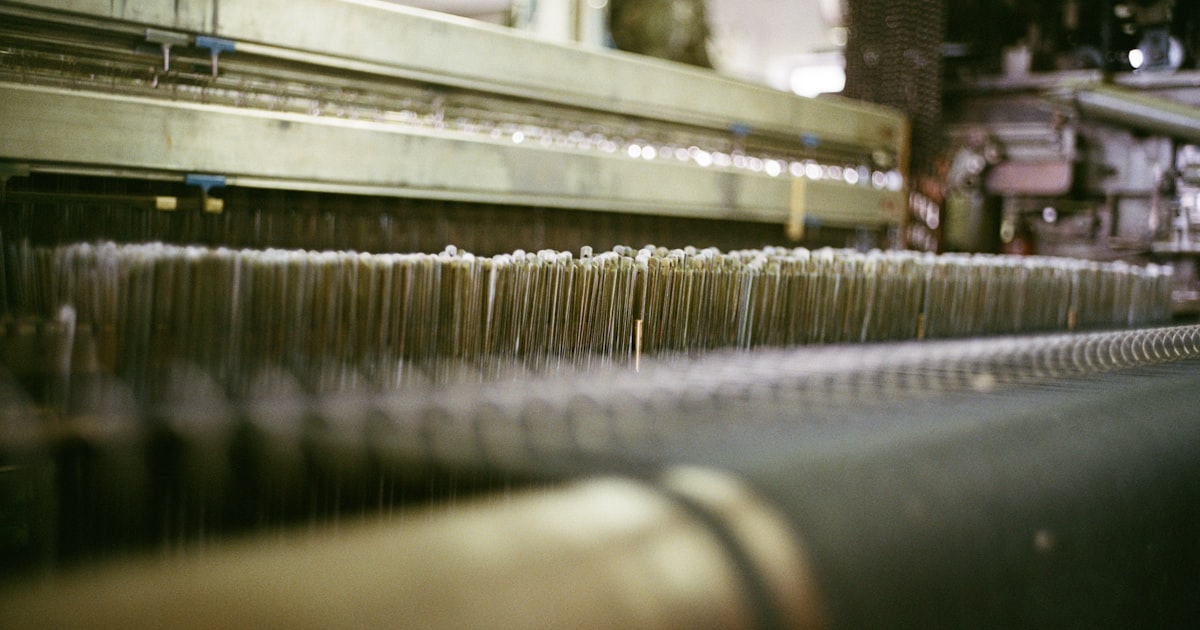 Close-up of threads on a large industrial loom.