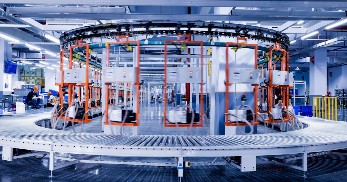 a large machine in a factory with people working on it