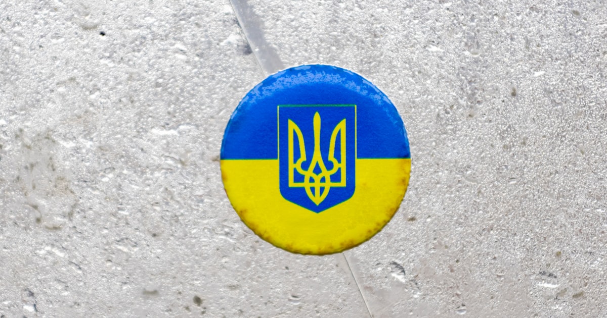 a blue and yellow frisbee with a coat of arms on it