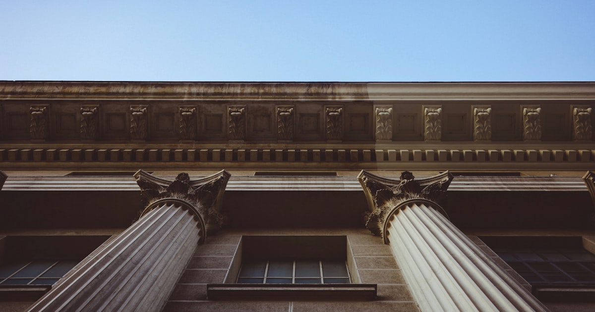 A tall building with columns and a sky background