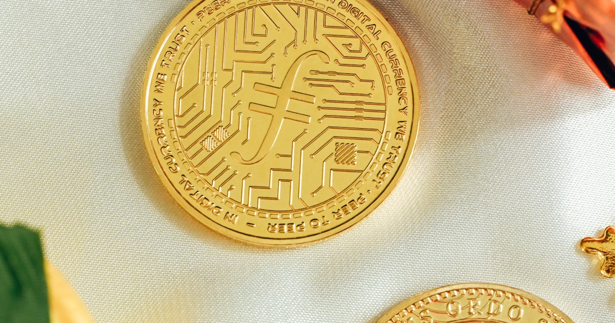 two gold coins sitting on top of a white cloth