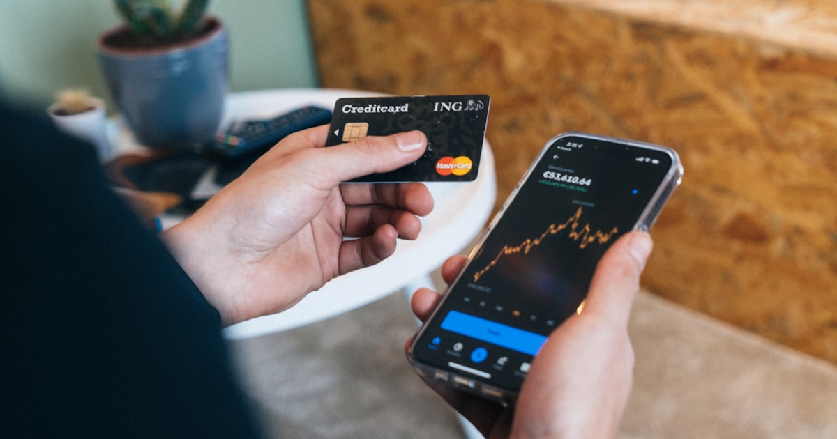 a person holding a smart phone and a credit card