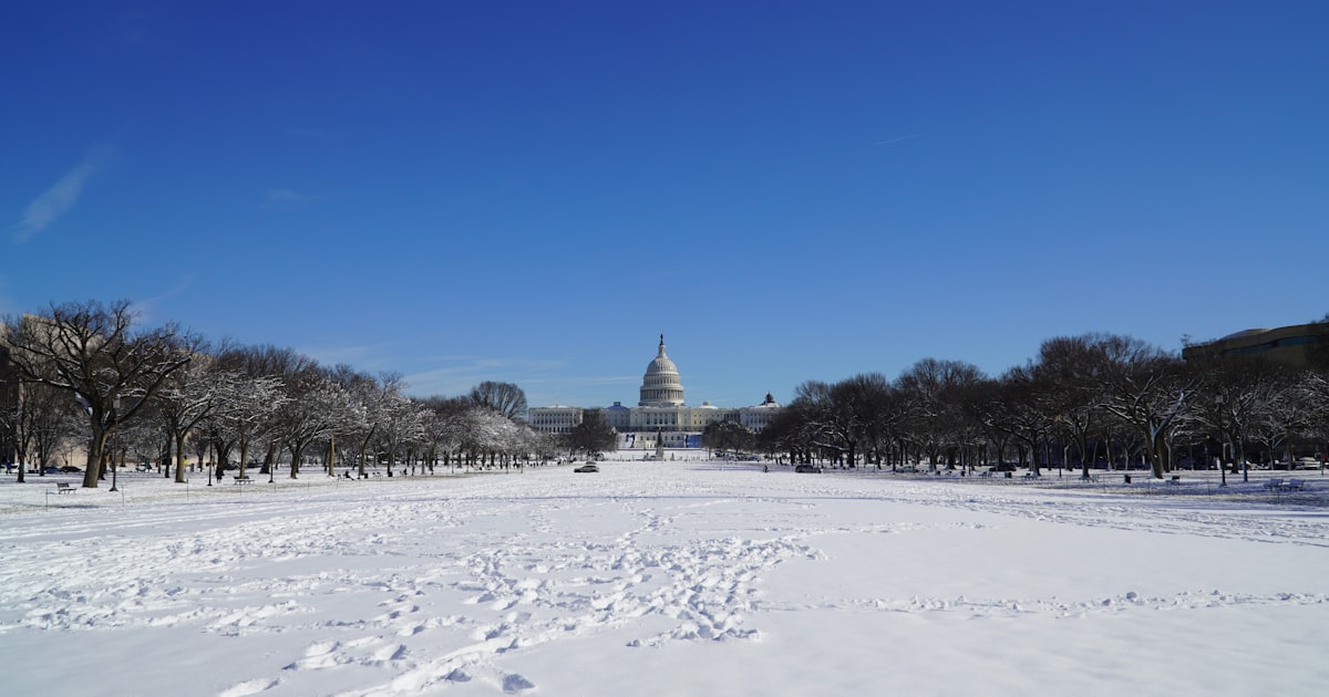 a view of the capital building from across a snowy field