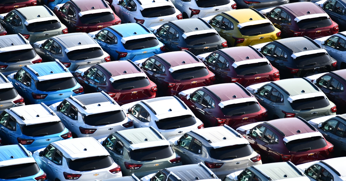 Rows of new cars parked in a large lot