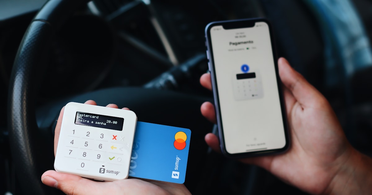a person holding a credit card and a mobile phone