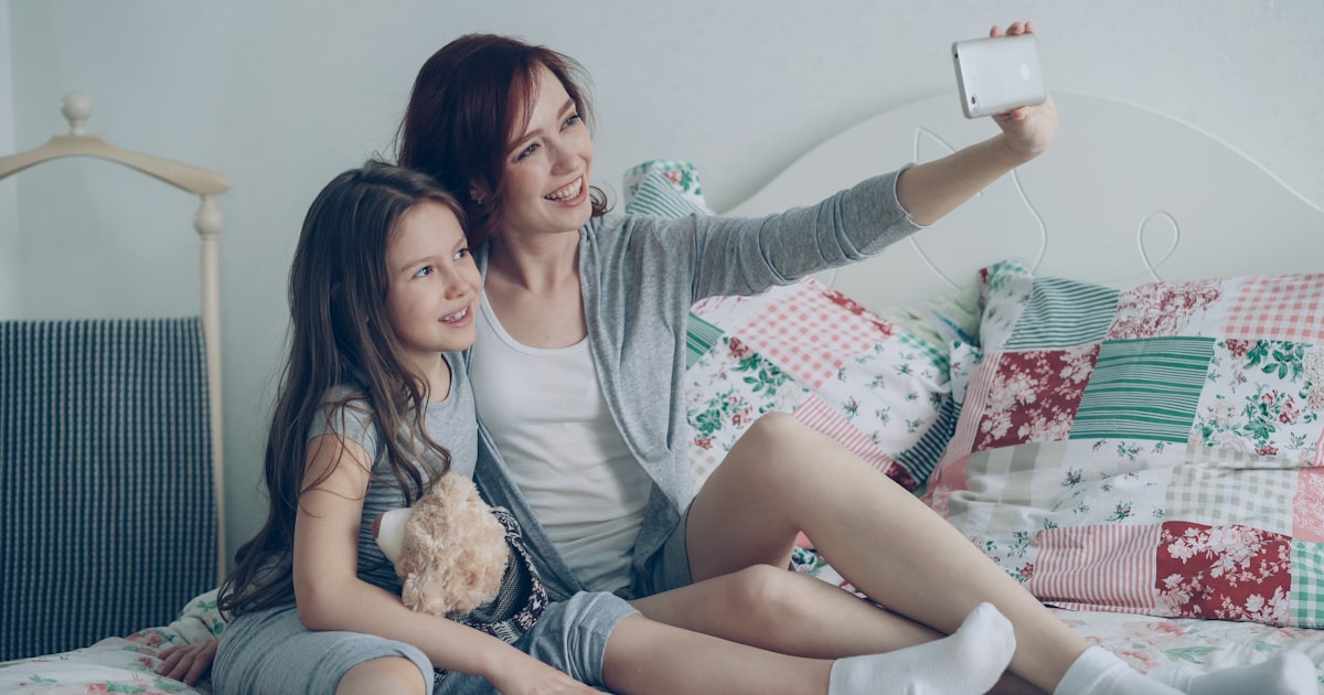 Mother and daughter take a selfie together.