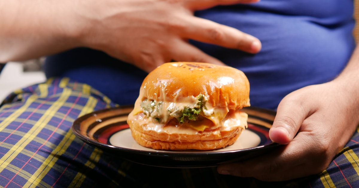 a person holding a plate with a sandwich on it