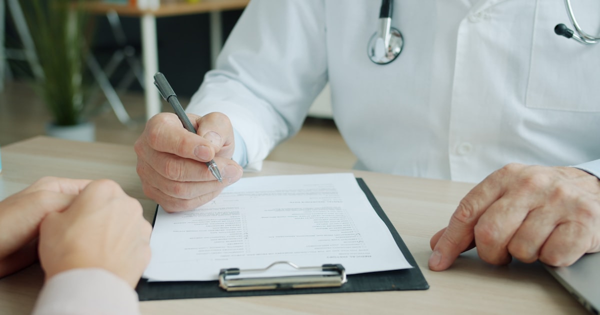Doctor writing on a patient's chart