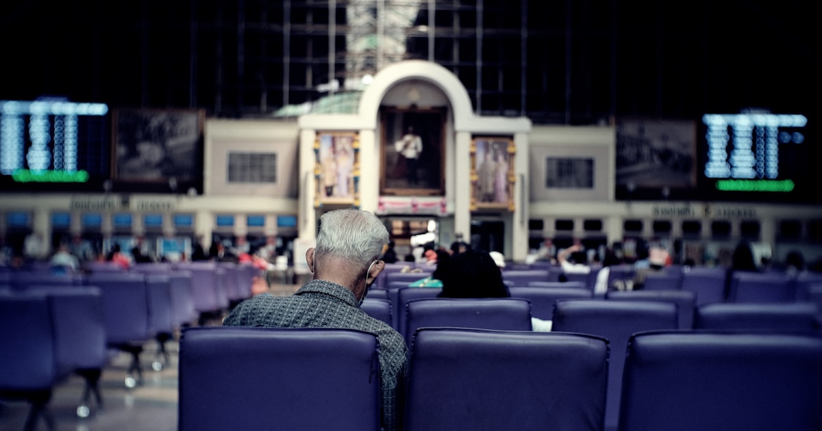 man in black jacket sitting on blue chair