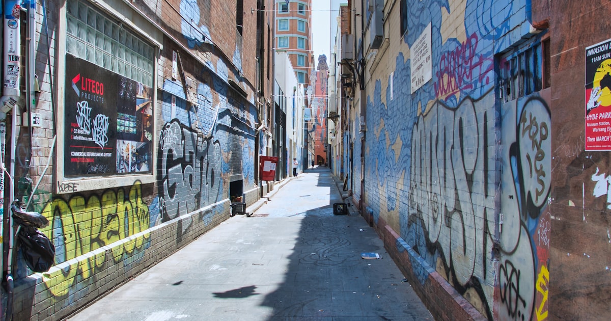 Graffiti-covered alleyway with buildings in the distance