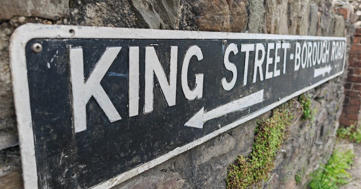 a street sign mounted to a stone wall