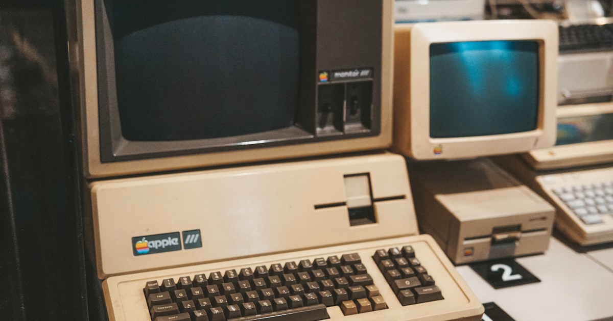 a row of old computers sitting on top of a desk