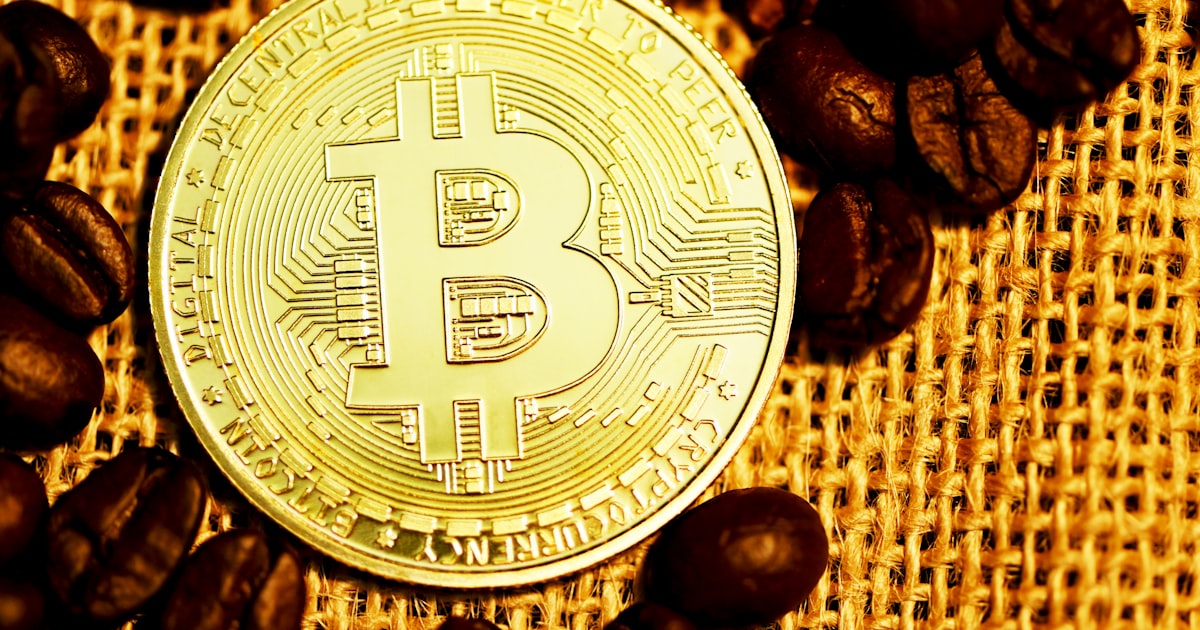 silver round coin on brown coffee beans