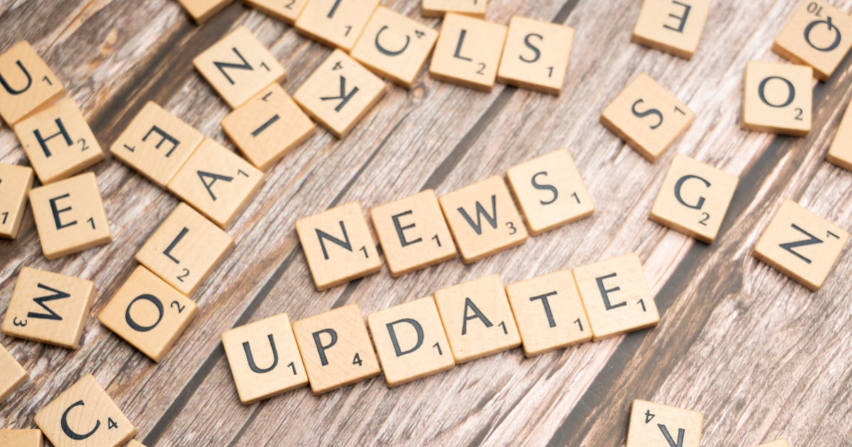 scrabble tiles spelling news update on a wooden table